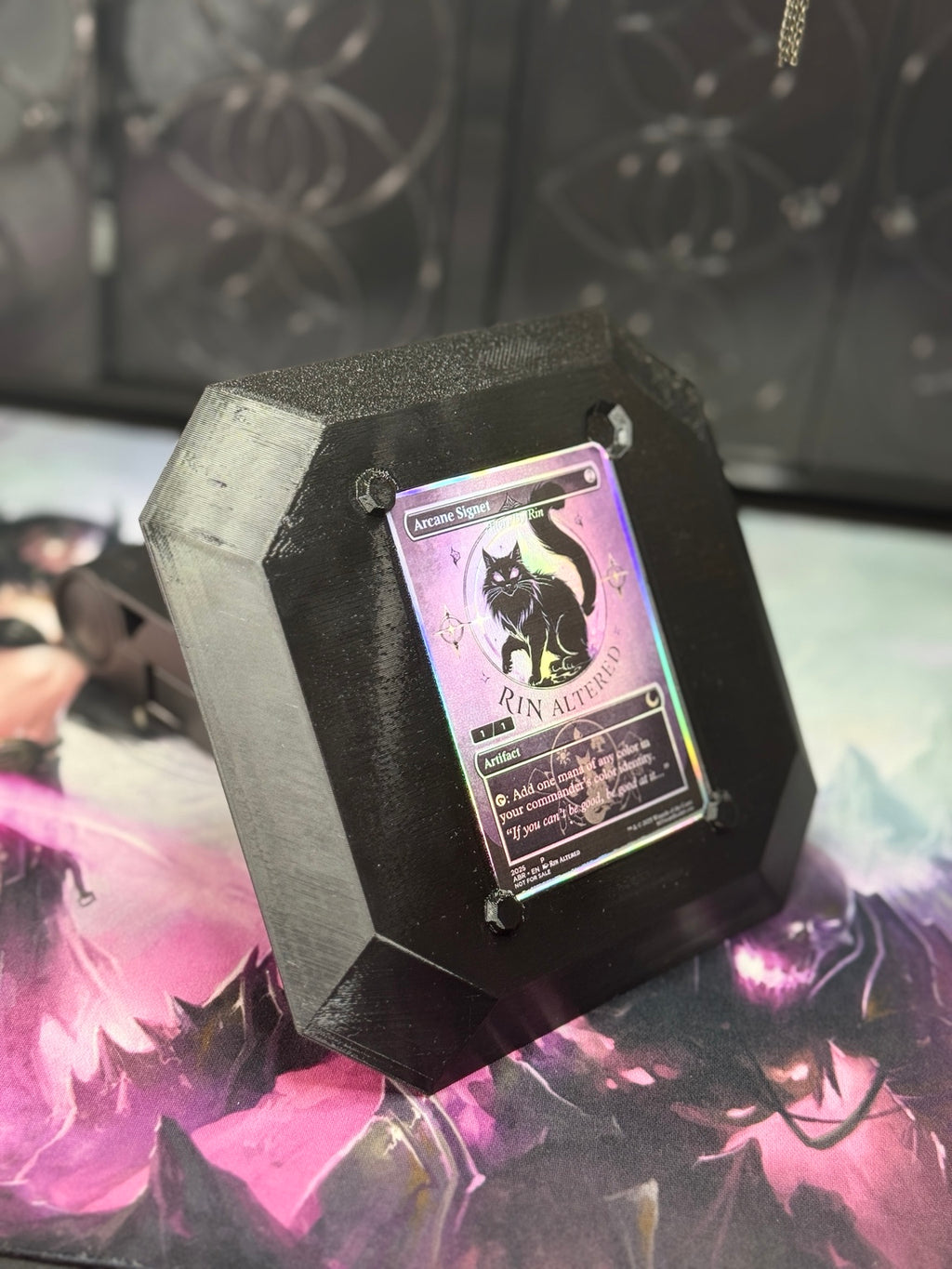 Black and iridescent 3D-printed Alter Board shown at an angle with a trading card