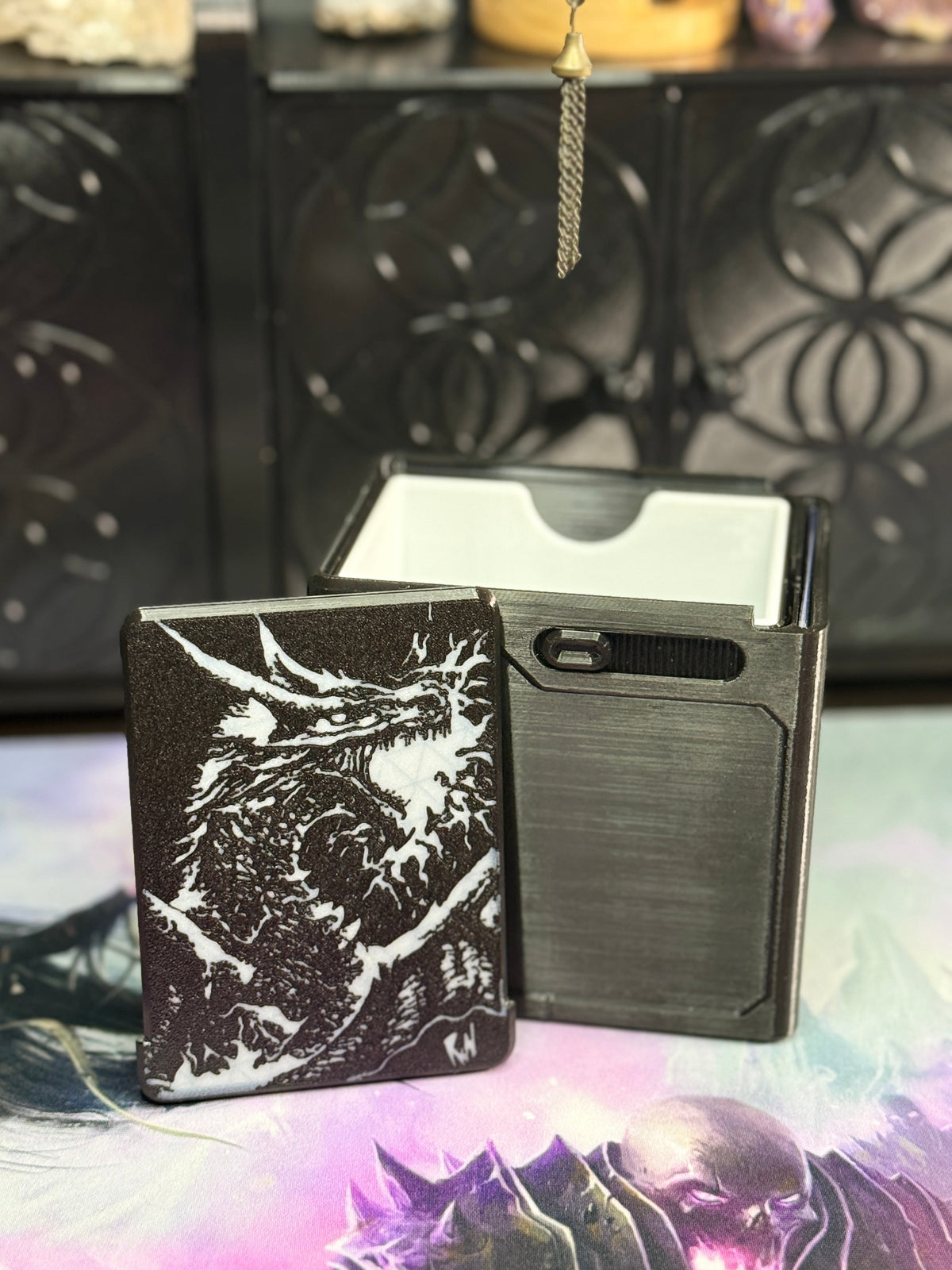 Open black dragon deck box showing removable artwork panel and card compartment