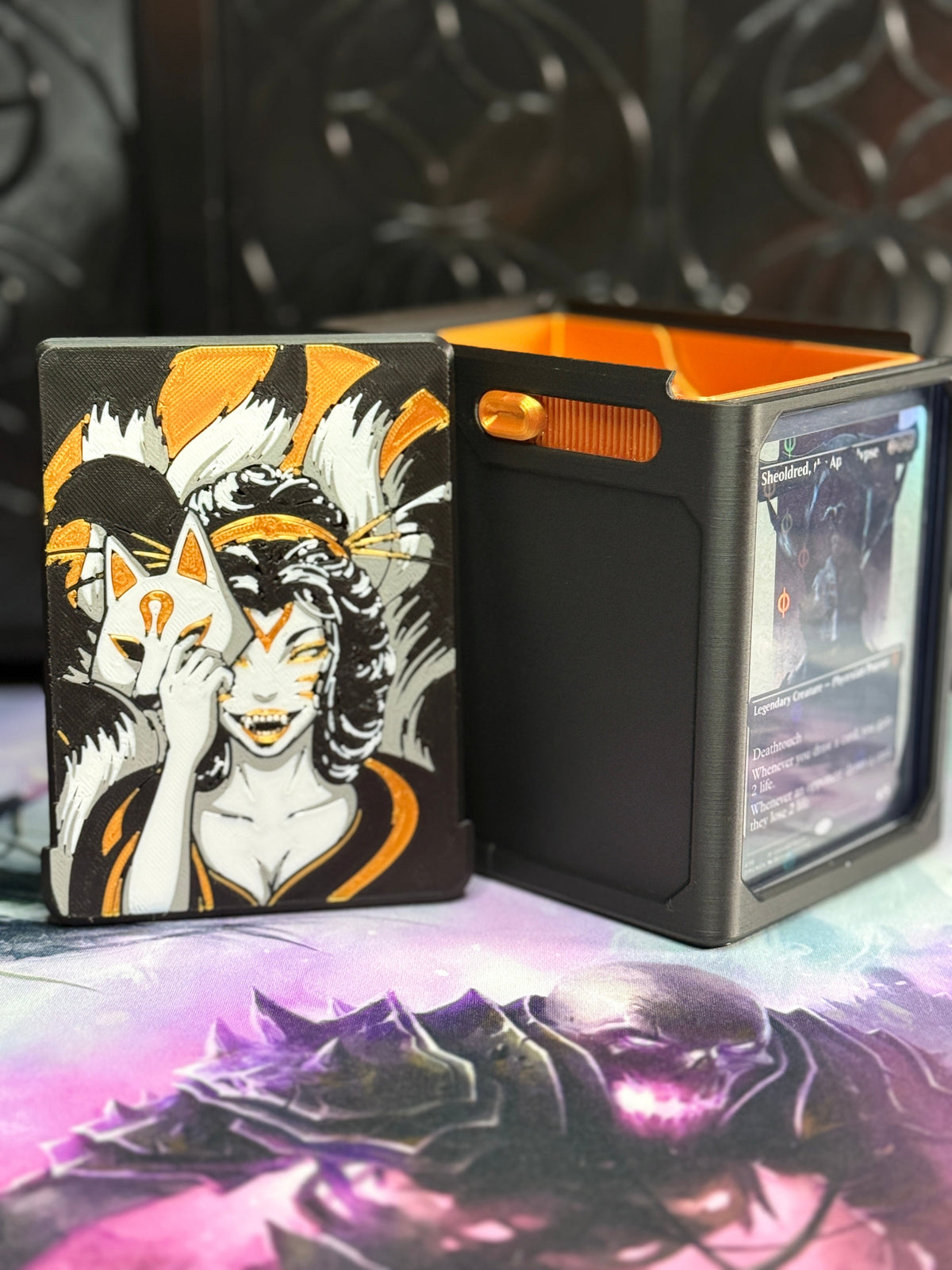 Black and gold Kitsune art panel beside the open deck box