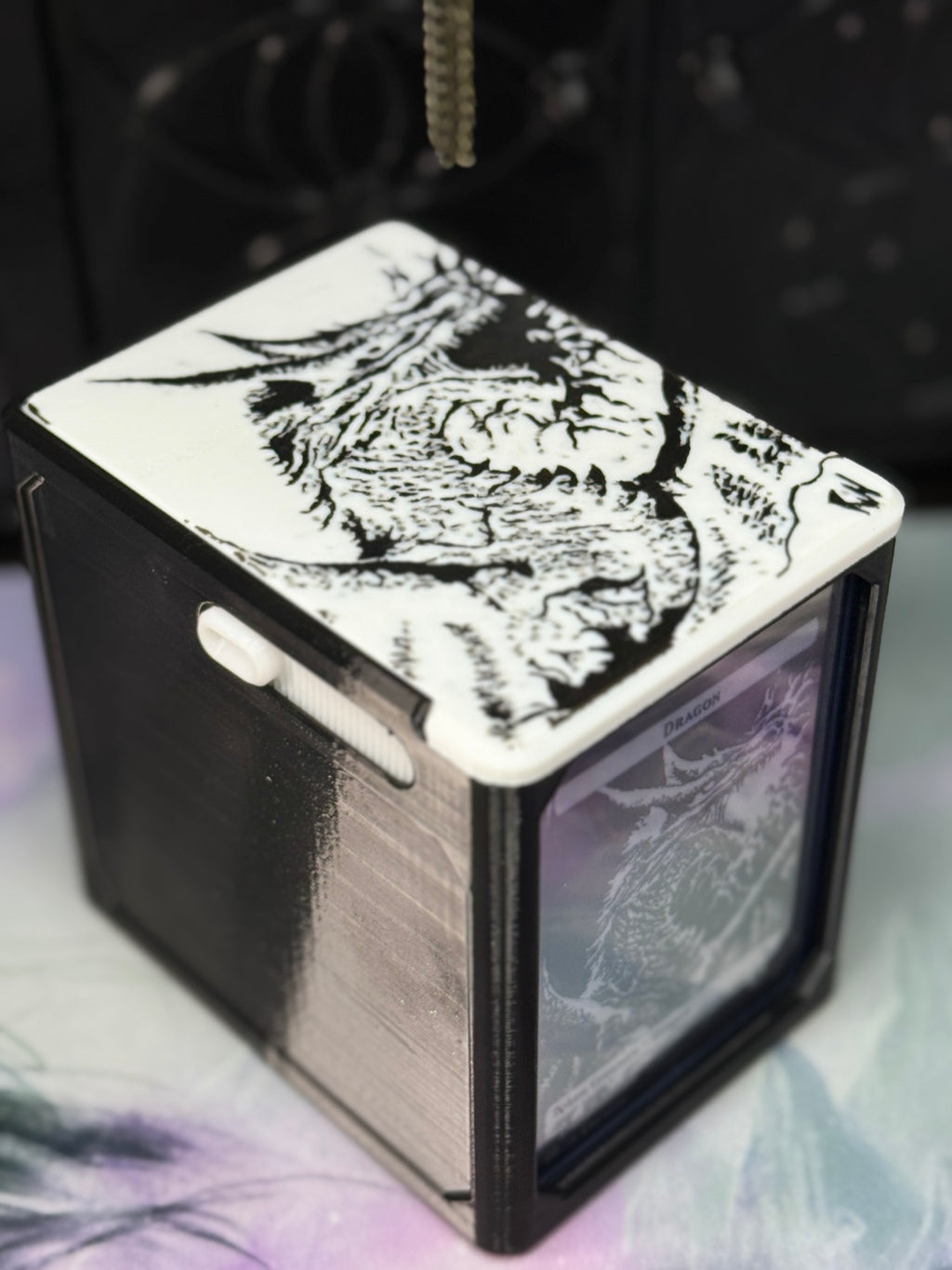 Black and white dragon art deck box with white illustrated top and card-display side