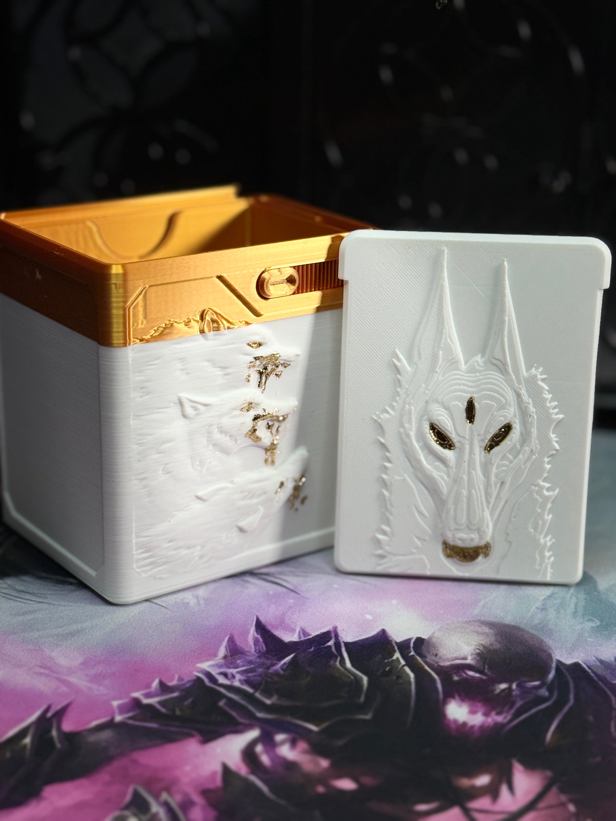 White and gold wolf relief art panel beside open box